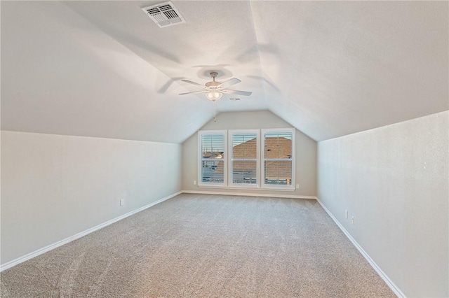 additional living space with ceiling fan, lofted ceiling, carpet floors, and a textured ceiling