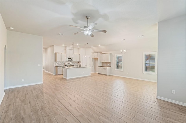 unfurnished living room with lofted ceiling, light hardwood / wood-style floors, and ceiling fan with notable chandelier