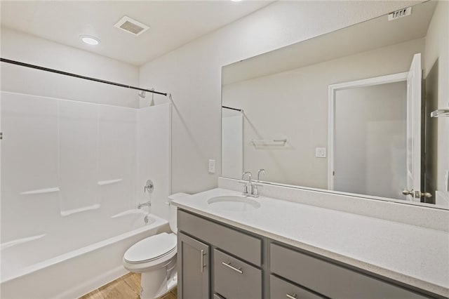 full bathroom featuring vanity, tub / shower combination, hardwood / wood-style floors, and toilet