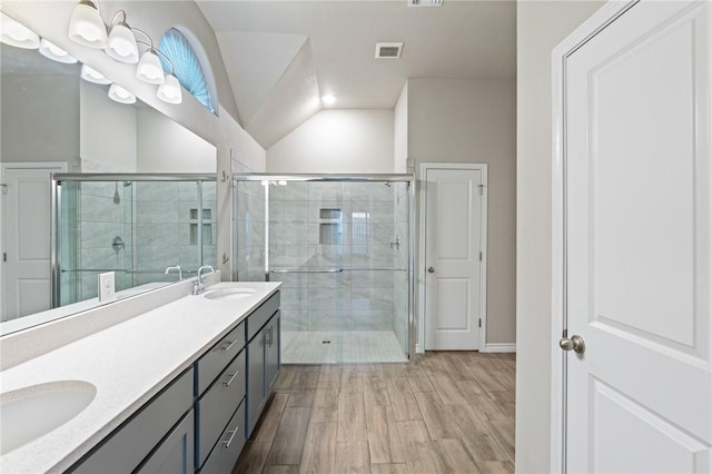 bathroom with a shower with door, vanity, lofted ceiling, and hardwood / wood-style flooring