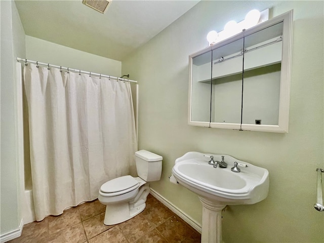 bathroom featuring toilet, shower / tub combo with curtain, and tile patterned flooring