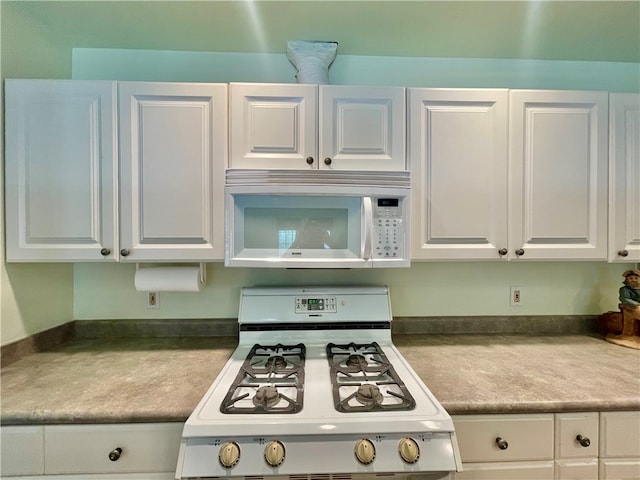 kitchen featuring white appliances and white cabinetry