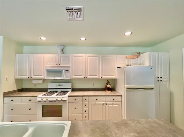 kitchen with white cabinetry and white appliances