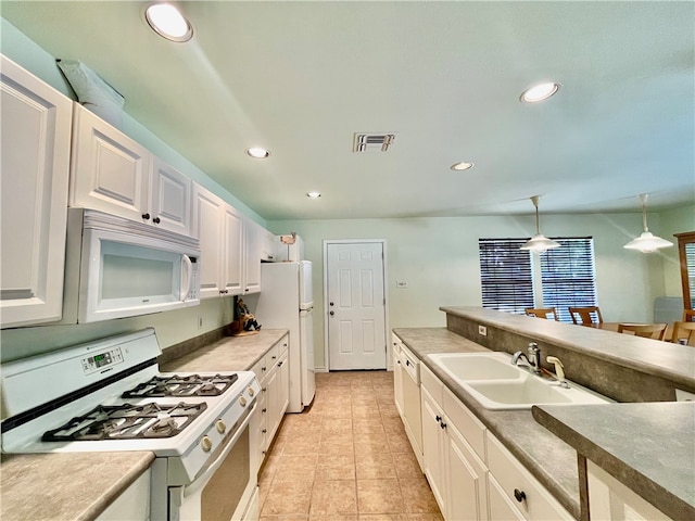 kitchen featuring white cabinets, hanging light fixtures, sink, light tile patterned floors, and white appliances