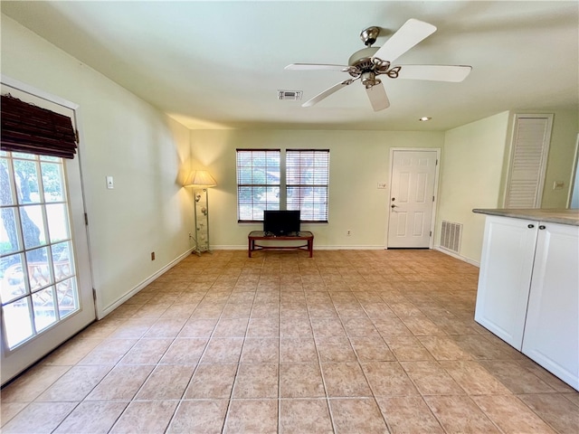 unfurnished room with ceiling fan and light tile patterned flooring