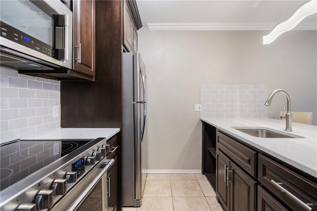 kitchen with a sink, dark brown cabinetry, light countertops, appliances with stainless steel finishes, and crown molding