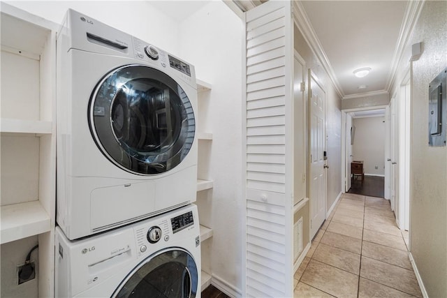 washroom with stacked washer / dryer, crown molding, baseboards, light tile patterned floors, and laundry area