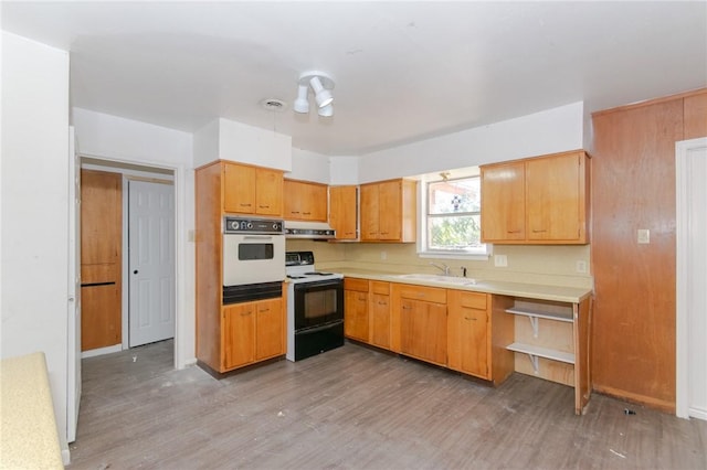 kitchen featuring white appliances, ventilation hood, light hardwood / wood-style floors, and sink