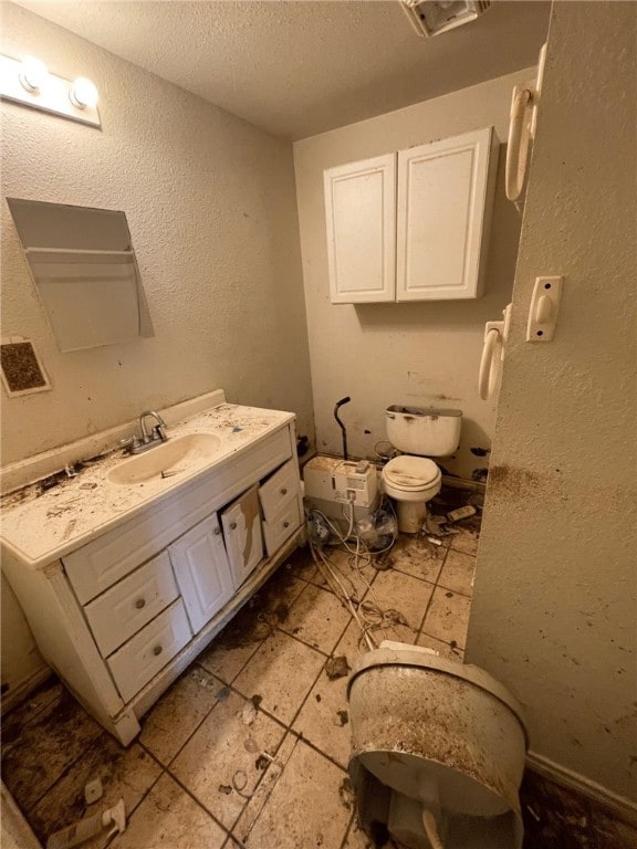 bathroom featuring vanity, toilet, and a textured ceiling