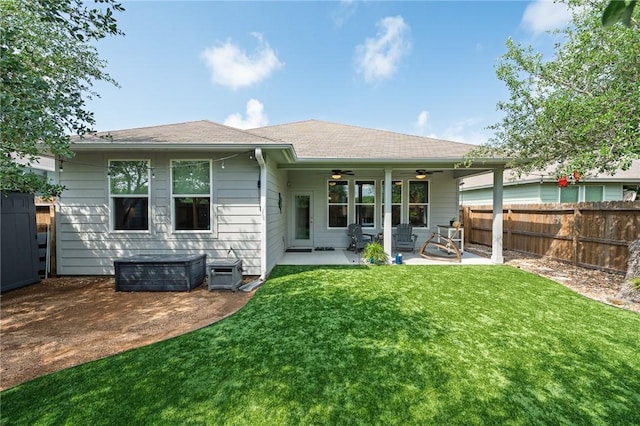 1962 Lighthouse Lakes Ln, Aransas Pass, TX 78336 - rear view of house with a fenced backyard, a shingled roof, ceiling fan, a patio area, and a lawn