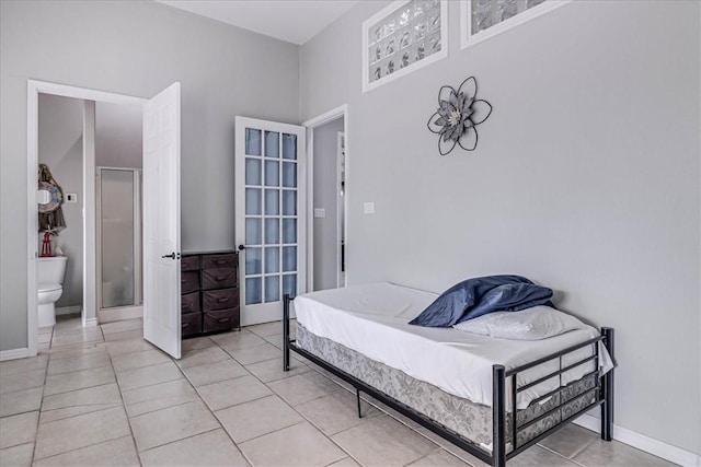 bedroom featuring ensuite bath and light tile patterned flooring