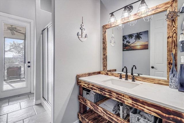 bathroom featuring a shower with door and vanity