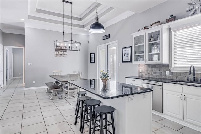 kitchen featuring sink, white cabinets, a raised ceiling, ornamental molding, and stainless steel dishwasher