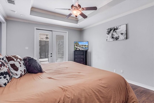 bedroom with ceiling fan, dark hardwood / wood-style flooring, french doors, and a raised ceiling