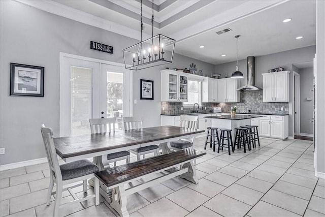 tiled dining room featuring sink and french doors