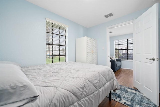 bedroom featuring baseboards, visible vents, and dark wood-type flooring