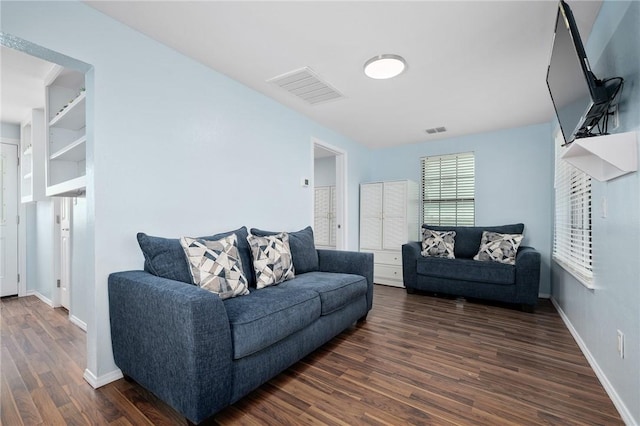 living room featuring baseboards, visible vents, and dark wood-type flooring