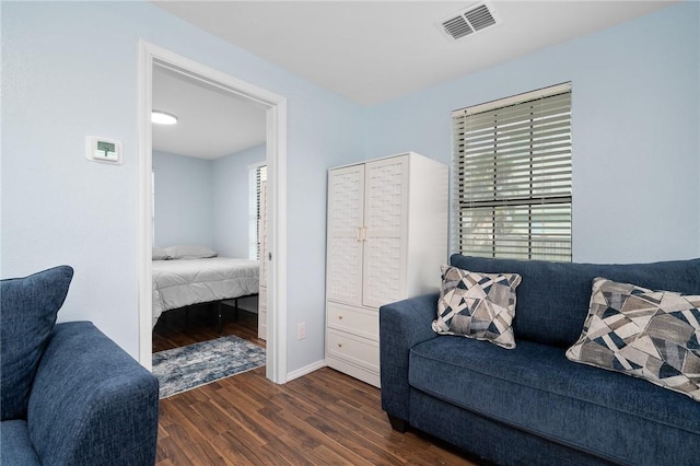 living room with baseboards, visible vents, and dark wood finished floors