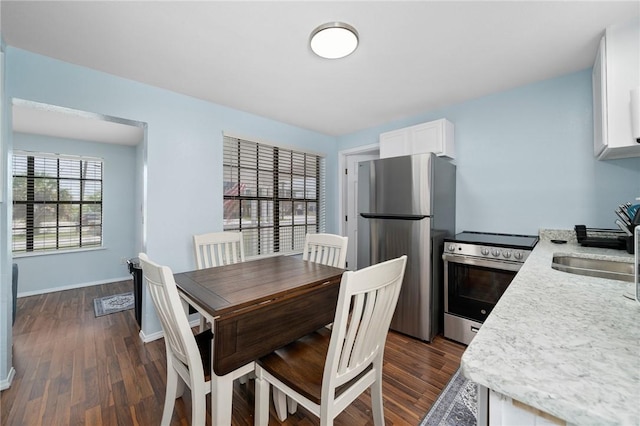 dining area featuring dark wood-style flooring and baseboards