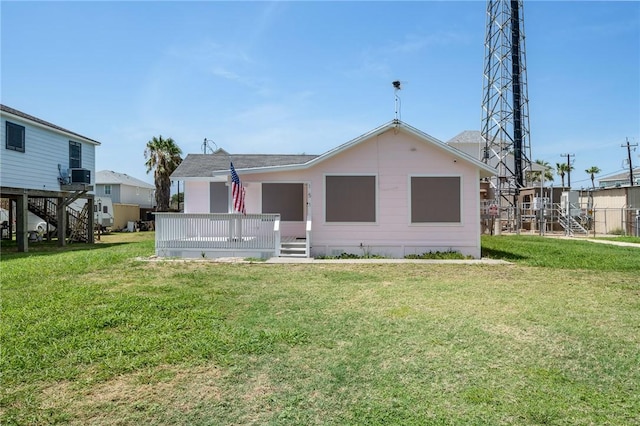 back of house with a deck, a yard, and a residential view