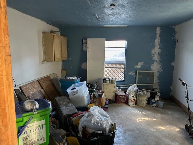 miscellaneous room with concrete floors and a textured ceiling