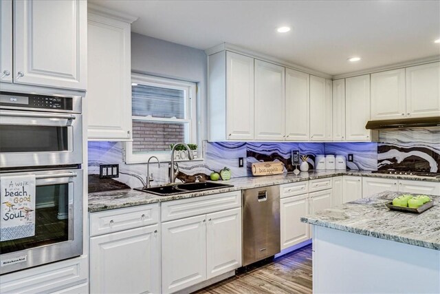 434 Cape Lookout Dr, Corpus Christi, TX 78412 - kitchen with white cabinets, under cabinet range hood, a sink, and stainless steel appliances