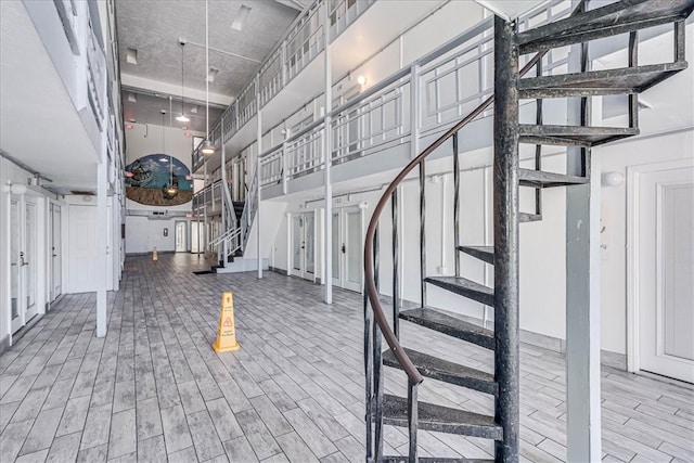 stairs with a towering ceiling and hardwood / wood-style flooring