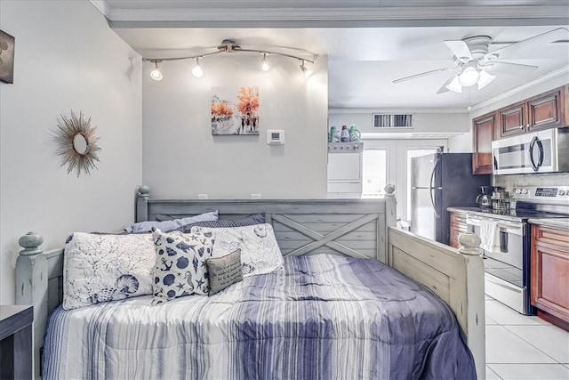 bedroom with black fridge, crown molding, ceiling fan, light tile patterned flooring, and washer / dryer