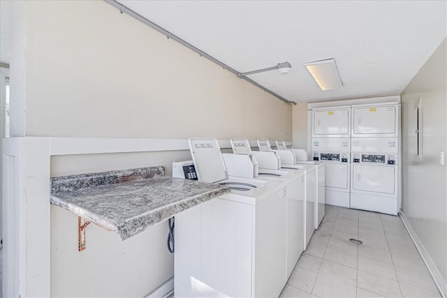 laundry room with light tile patterned floors, stacked washer and dryer, and independent washer and dryer