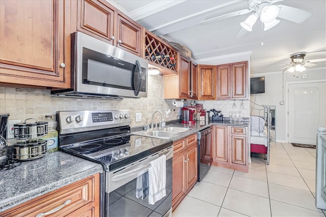 kitchen featuring light tile patterned floors, sink, appliances with stainless steel finishes, and tasteful backsplash