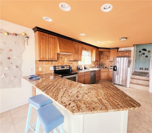13757 Cayo Gorda Ct, Corpus Christi, TX 78418 - kitchen with stainless steel appliances, premium range hood, light stone counters, decorative backsplash, and recessed lighting