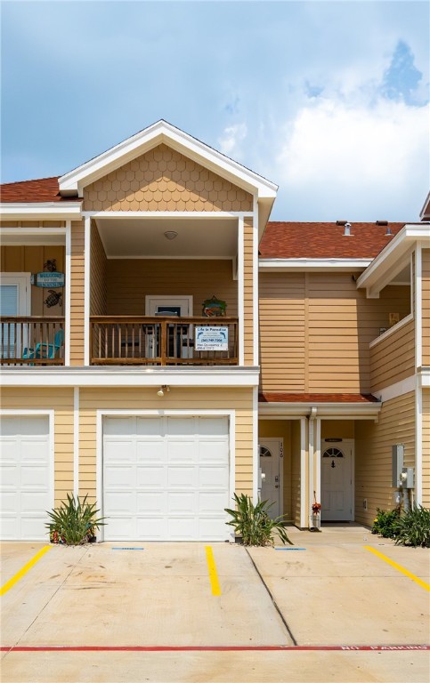 view of property with a garage and a balcony