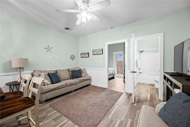 living room with light hardwood / wood-style floors and ceiling fan