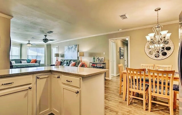 kitchen featuring hanging light fixtures, visible vents, and open floor plan