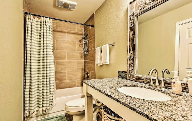 bathroom featuring vanity, visible vents, shower / bath combo with shower curtain, toilet, and a textured wall