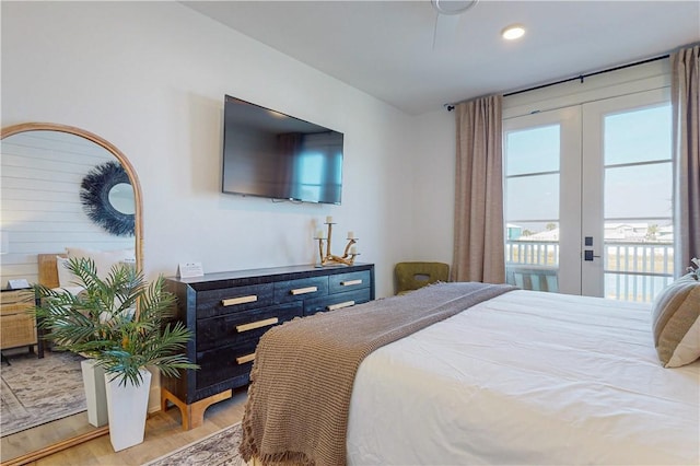 bedroom featuring access to outside, light hardwood / wood-style floors, and french doors