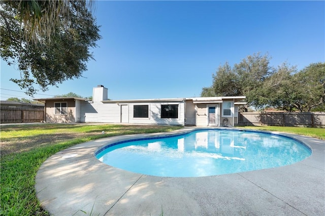 view of swimming pool featuring a lawn