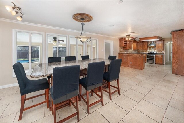 tiled dining room featuring crown molding and ceiling fan