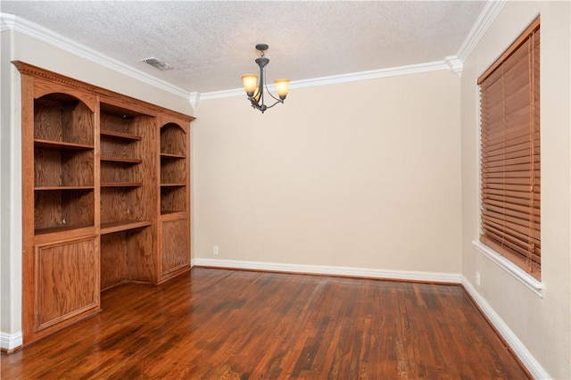 empty room with a textured ceiling, dark hardwood / wood-style floors, crown molding, and a notable chandelier