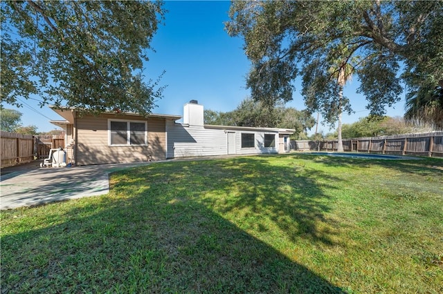 rear view of property featuring a lawn and a patio