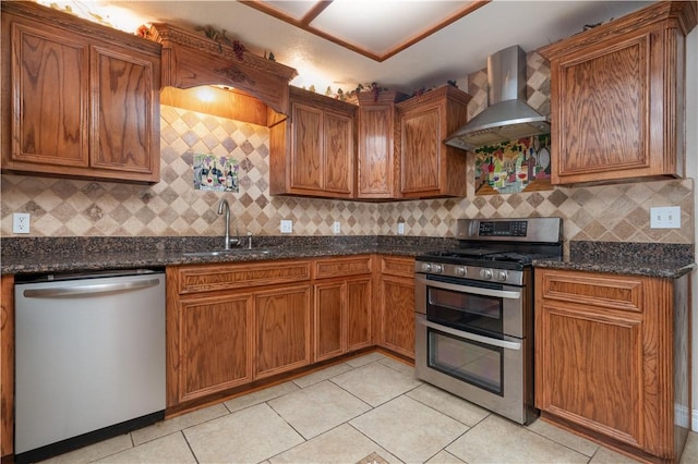 kitchen featuring backsplash, wall chimney range hood, sink, light tile patterned flooring, and stainless steel appliances