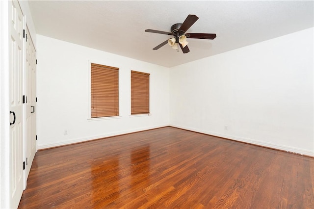 empty room featuring ceiling fan and dark wood-type flooring