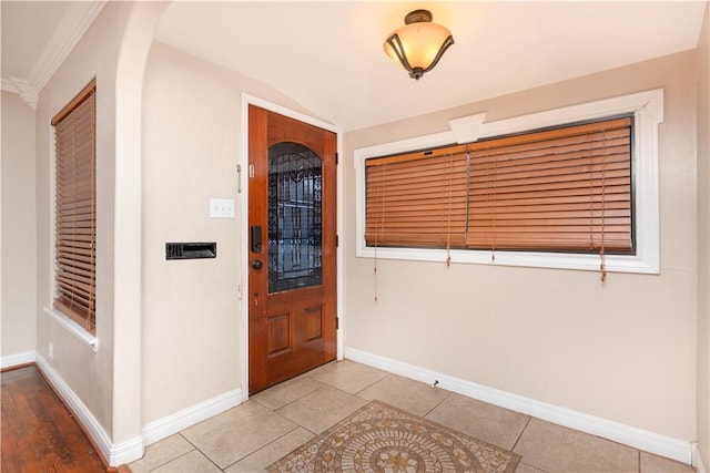 entrance foyer featuring light tile patterned floors and ornamental molding