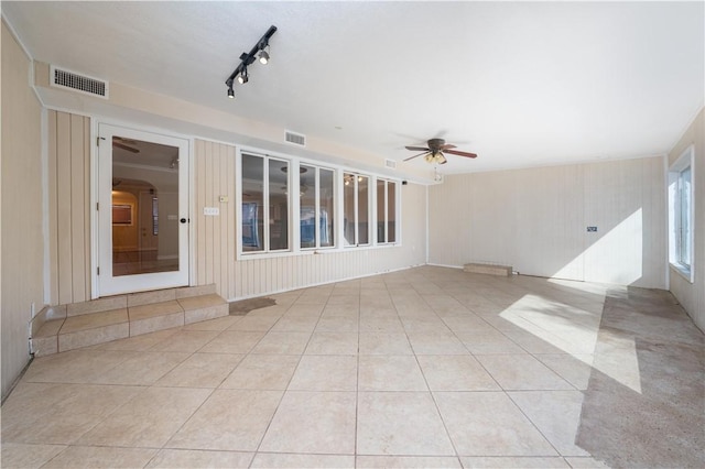 interior space with track lighting, ceiling fan, and light tile patterned flooring