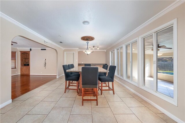 dining room with crown molding and light tile patterned floors