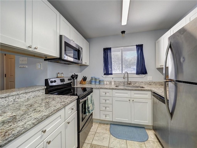 kitchen with stainless steel appliances, white cabinetry, and sink