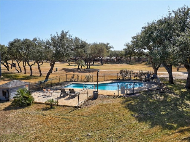 view of pool with a patio and a lawn