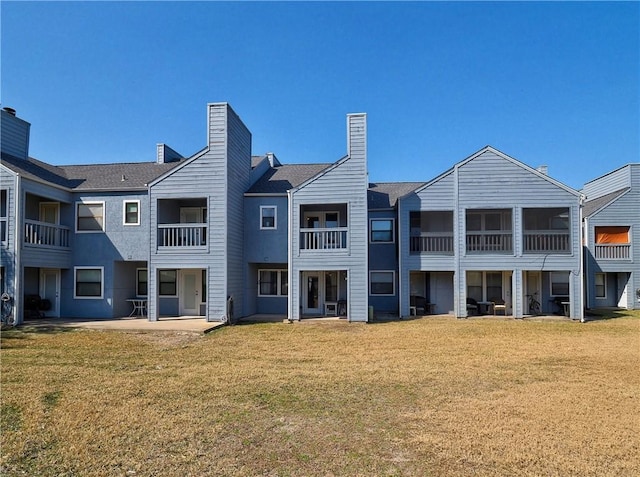 rear view of house with a patio area and a lawn