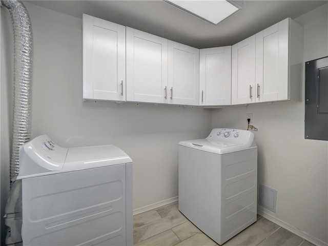 clothes washing area featuring washer and clothes dryer, electric panel, and cabinets