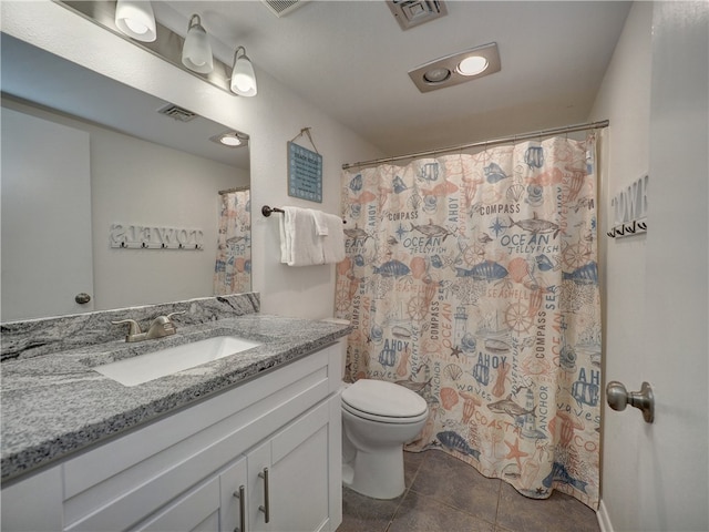 bathroom featuring vanity, tile patterned floors, and toilet